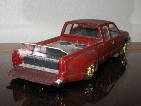 1977 Ford F-150 - Model truck with custom bed modification and gold rims is viewed from the rear.