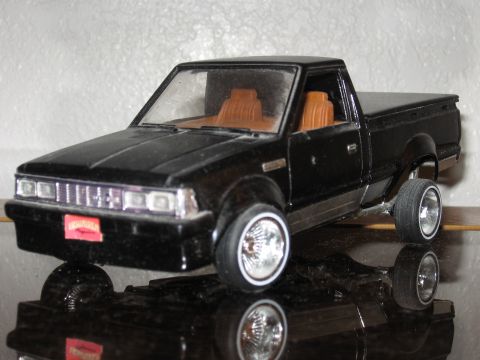 1977 Ford F-150 - Model truck with custom wheels and lowered suspension sits on a reflective surface.