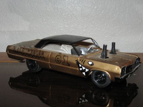 1977 Ford F-150 - Customized model car painted gold with 'FORD KILLER' and shark teeth graphics.