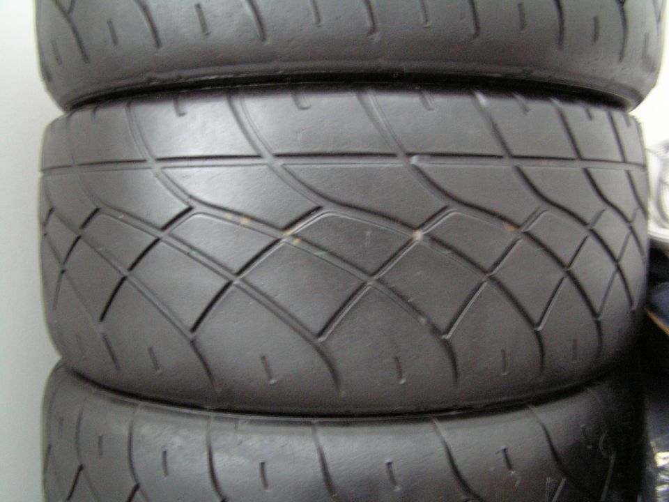 stacked tires with a diamond tread pattern. Supermotors.net logo in corner