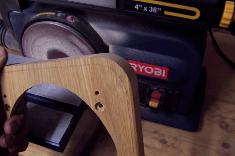 1990 Ford Bronco - A wooden speaker adapter part is being worked on with a Ryobi belt sander.