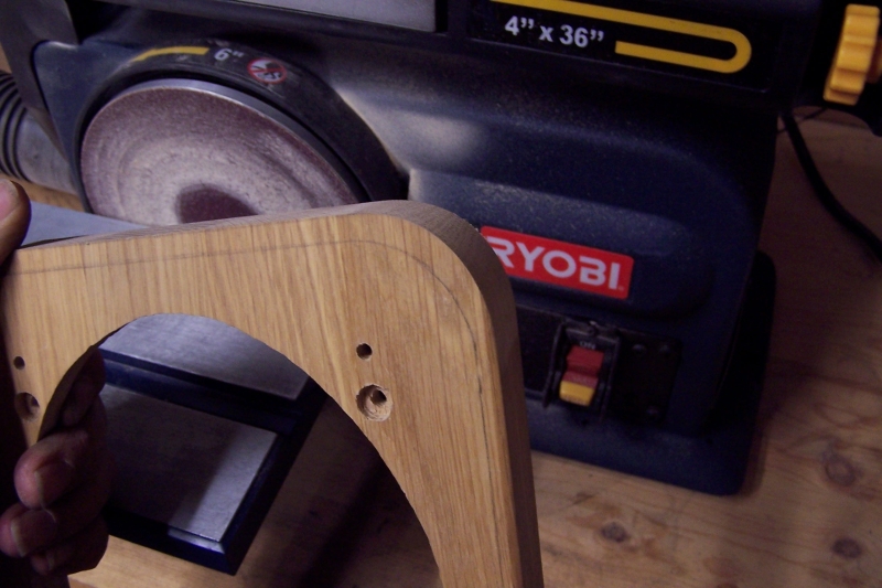 Wood part being held in front of a Ryobi belt sander
