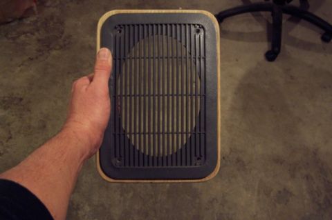 1990 Ford Bronco - A speaker adapter is held up for inspection against a concrete floor.