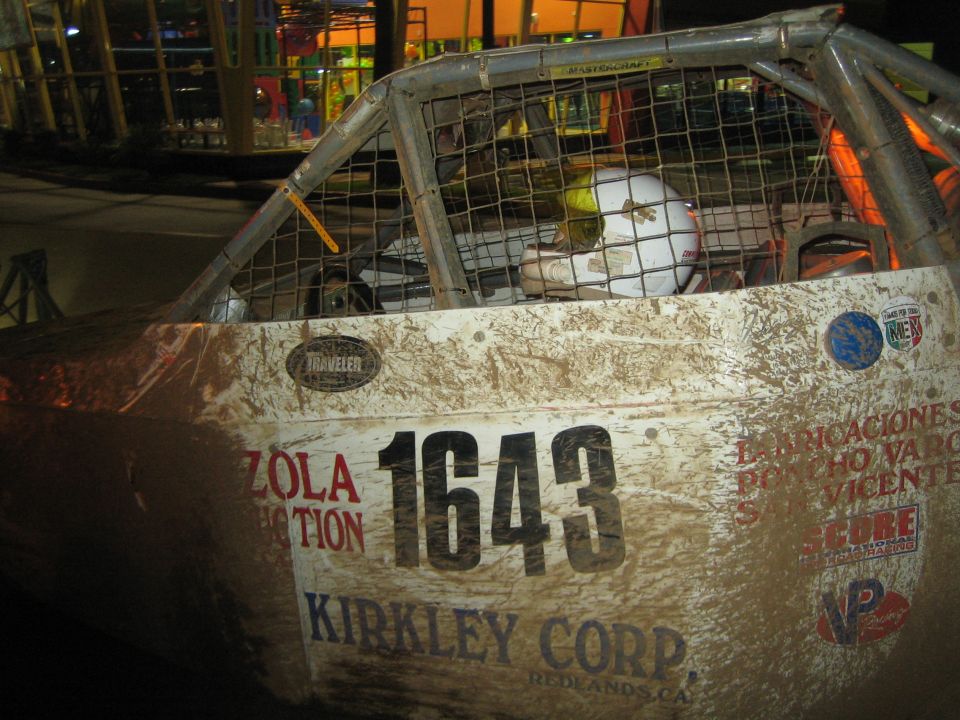 Dirty race truck cab with mesh window and door number 1643 at night event