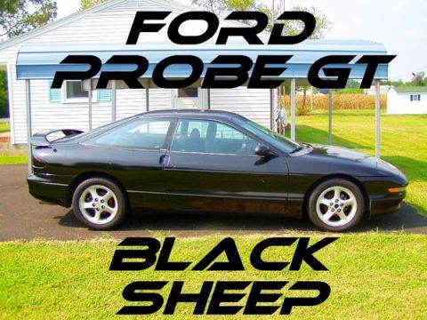 1993 Ford Probe - A black 1993 Ford Probe GT is shown parked in front of a residential building with a carport overhead.