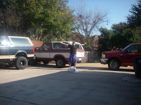 1978 Ford Bronco - Three vehicles are parked in a driveway, including a 1978 Ford Bronco.