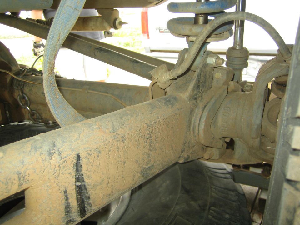 Dusty axle, coil spring and steering knuckle under an off-road vehicle