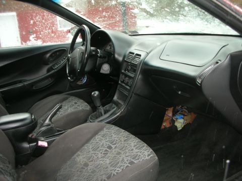 1995 Ford Probe - The interior of a 1995 Ford Probe is shown, fabric seats and a manual transmission shifter.