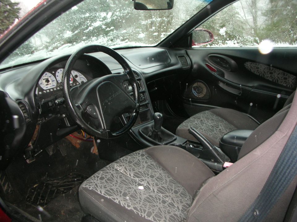 Interior of a coupe with manual shifter and cloth seats