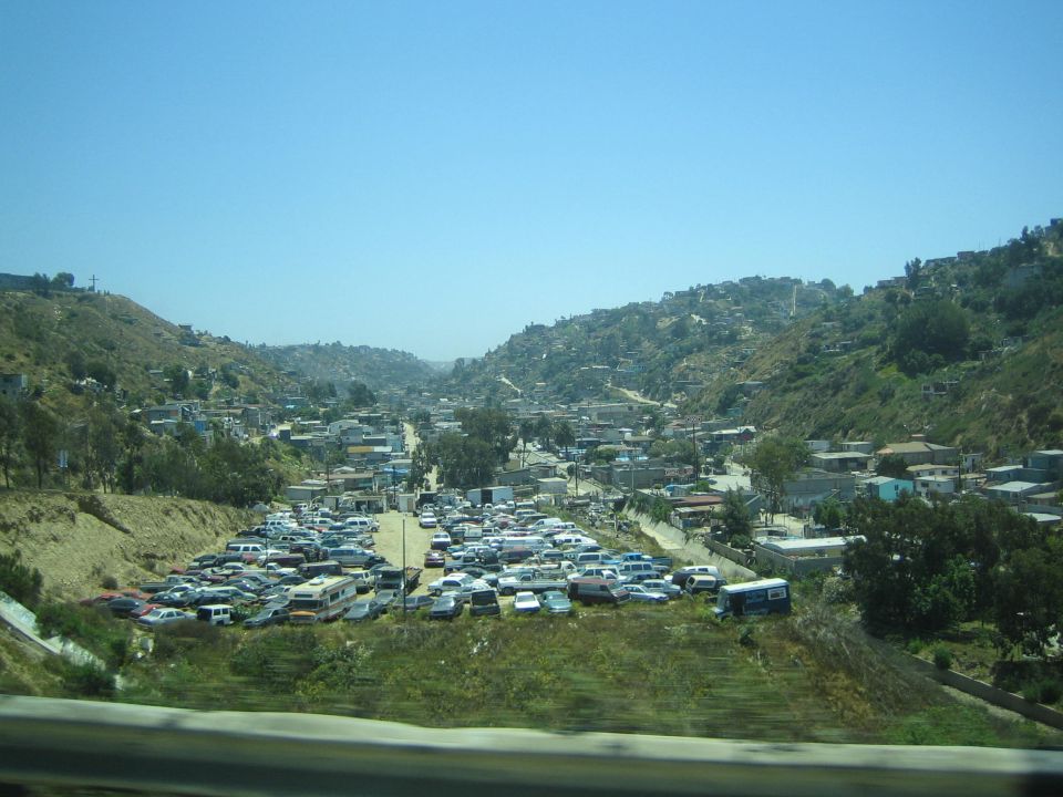 Hillside town packed with parked cars and houses under a clear blue sky