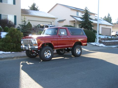 1979 Ford Bronco - This lifted red Ford Bronco features chrome wheels and a prominent grille.