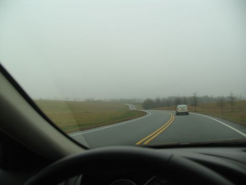 1978 Ford Bronco - Driving on a winding road through a foggy landscape with another vehicle ahead.