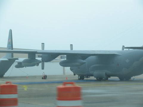 1978 Ford Bronco - Two large military cargo planes are parked on an airfield under a cloudy sky.