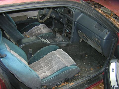 1987 Ford Thunderbird - The interior of a 1987 Ford Thunderbird shows its age with worn seats and a dusty dashboard.