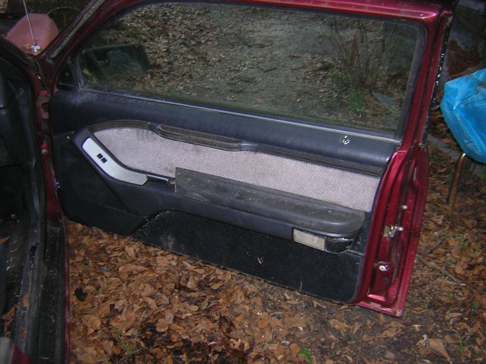 1987 Ford Thunderbird interior door panel with fabric insert and armrest