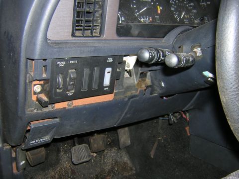 1987 Ford Thunderbird - Interior view of a car's dashboard, showing various switches and pedals, with the steering column and instrument cluster partially visible.