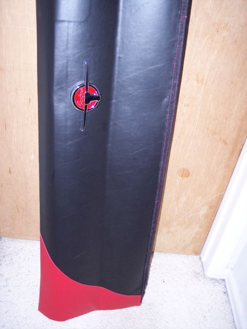 1972 Ford Ranchero - Close-up of a car door panel a red and black design with a chrome emblem.