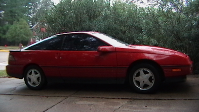 1989 Ford Probe coupe, side view, red paint, tinted windows