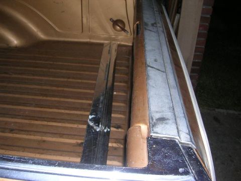 1975 Ford Ranchero - Close-up of the bed of a 1975 Ford Ranchero, showing wood-grain flooring and chrome trim.