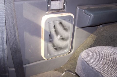 1990 Ford Bronco - Close-up of a speaker adapter installed on the interior door panel of a vehicle.