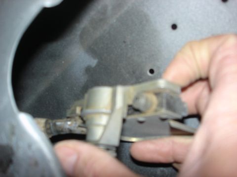 1979 Ford Bronco - Close-up of a hand manipulating a metal latch mechanism.