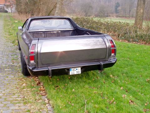 1972 Ford Ranchero - The rear of a 1972 Ford Ranchero is visible, parked on the side of a grassy area with a cobblestone path.