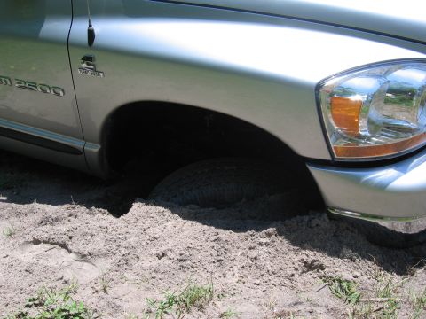 1974 Ford F-100 - This silver Dodge Ram 2500 Turbo Diesel is stuck in the sand, with its front wheel buried.