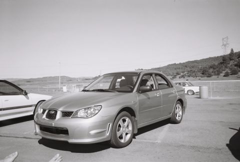 1988 Mazda MX-6 - Silver sedan parked on asphalt with a white car to its left under a clear sky.