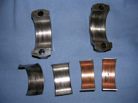 1996 Ford Probe - Several engine bearings are shown, some exhibiting significant wear and damage.