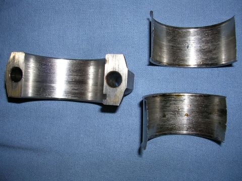 1996 Ford Probe - Engine bearing shells show significant wear and scoring, indicating potential internal engine damage.