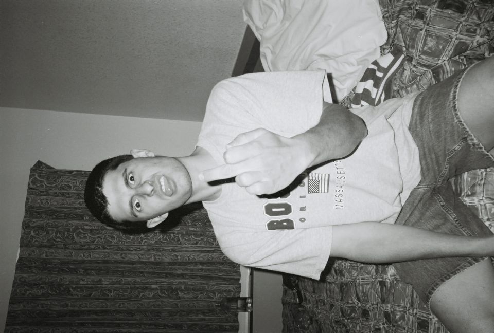 Man in t-shirt and denim shorts making a rude gesture