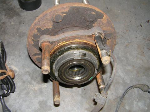 2000 Ford Excursion - Dana 50 front hub assembly, likely from a 4x4 truck or SUV, showing wear and grease.
