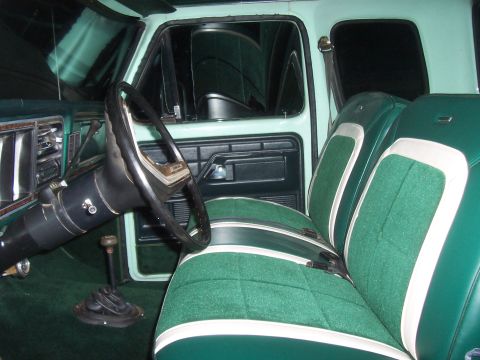 1994 Ford F-150 - The interior features a green bench seat with white accents and a column-mounted gear shifter.
