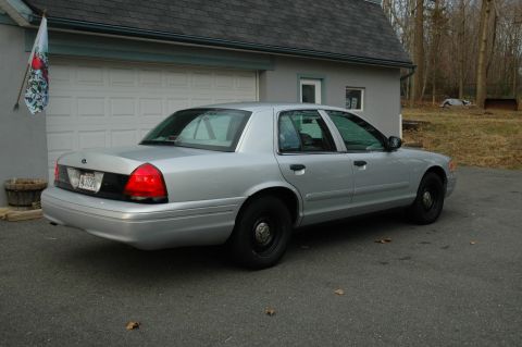 2003 Ford Crown Victoria - This silver 2003 Ford Crown Victoria is parked in front of a garage.