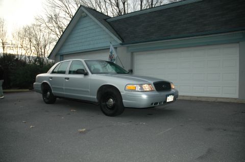2003 Ford Crown Victoria - This silver sedan is parked in front of a white garage door. The vehicle appears to be a 2003 Ford Crown Victoria.