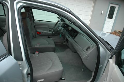 2003 Ford Crown Victoria - Interior view of a silver 2003 Ford Crown Victoria, showing the front seats, dashboard, and steering wheel.