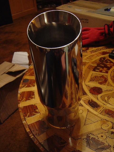 1986 Ford Bronco II - Chrome exhaust tip on a decorative table. Background shows gloves and a box.