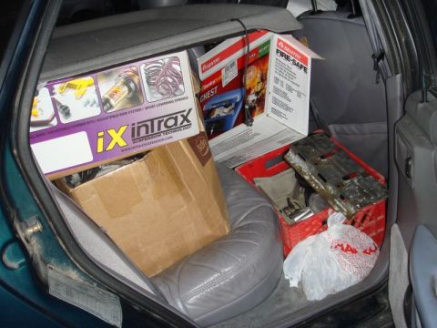 1993 Ford Taurus - The rear of a car is filled with various boxes and items, obscuring the view of the vehicle itself.