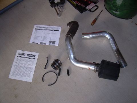 1996 Ford Probe - Parts for a K&N performance intake system are laid out on a concrete floor with installation instructions.
