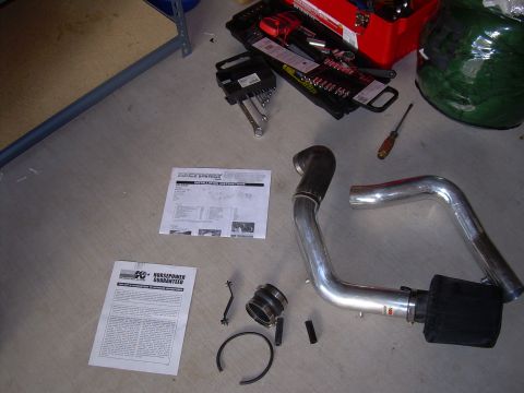 1996 Ford Probe - Parts for a cold air intake system, including tubing, filter, and instructions, are arranged on the floor.