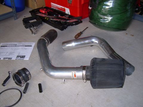 1996 Ford Probe - A cold air intake system is laid out on a concrete floor next to a toolbox and other tools.