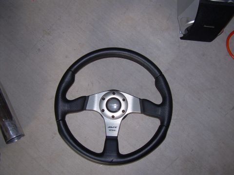 1996 Ford Probe - A black leather steering wheel with a silver center hub and MOMO branding is shown on a concrete floor.