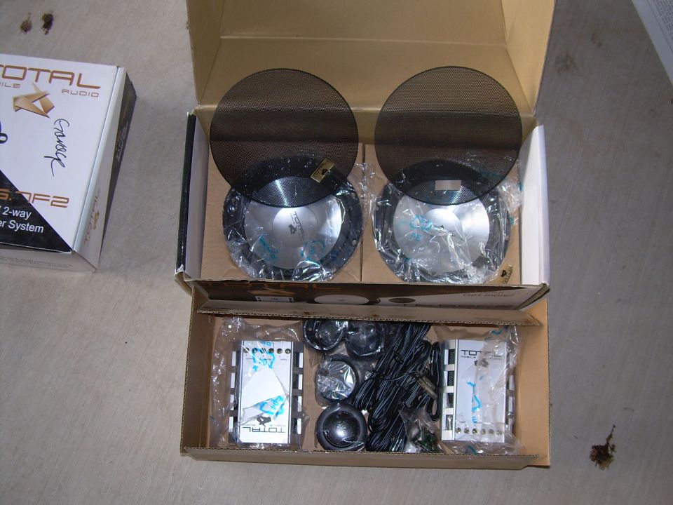 Two car audio speakers in boxes with crossovers and wiring
