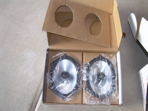 1996 Ford Probe - A pair of new car speakers are packaged in a cardboard box, ready for installation.