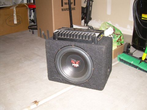 1996 Ford Probe - A car audio subwoofer with an amplifier stacked on top. The subwoofer has 'MTX' branding visible.