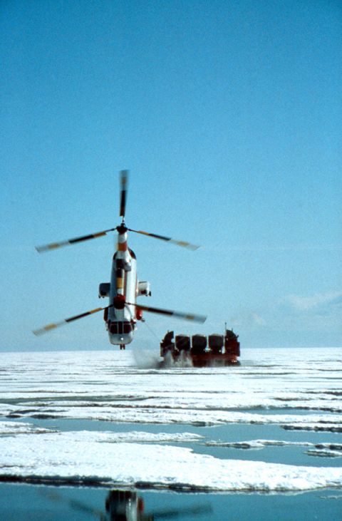 2000 Ford E350 - A helicopter flies above a cargo sled on a frozen landscape.