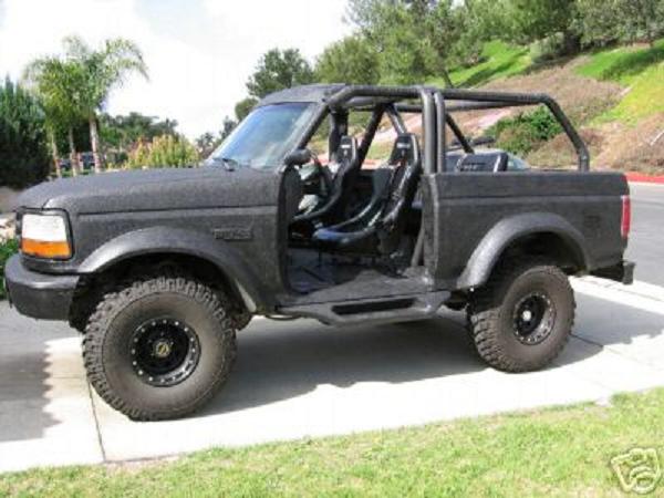 Black Ford Bronco with roll cage and racing seats, doors removed