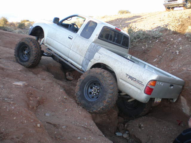 Silver Toyota Tacoma TRD off-road climbing rocks