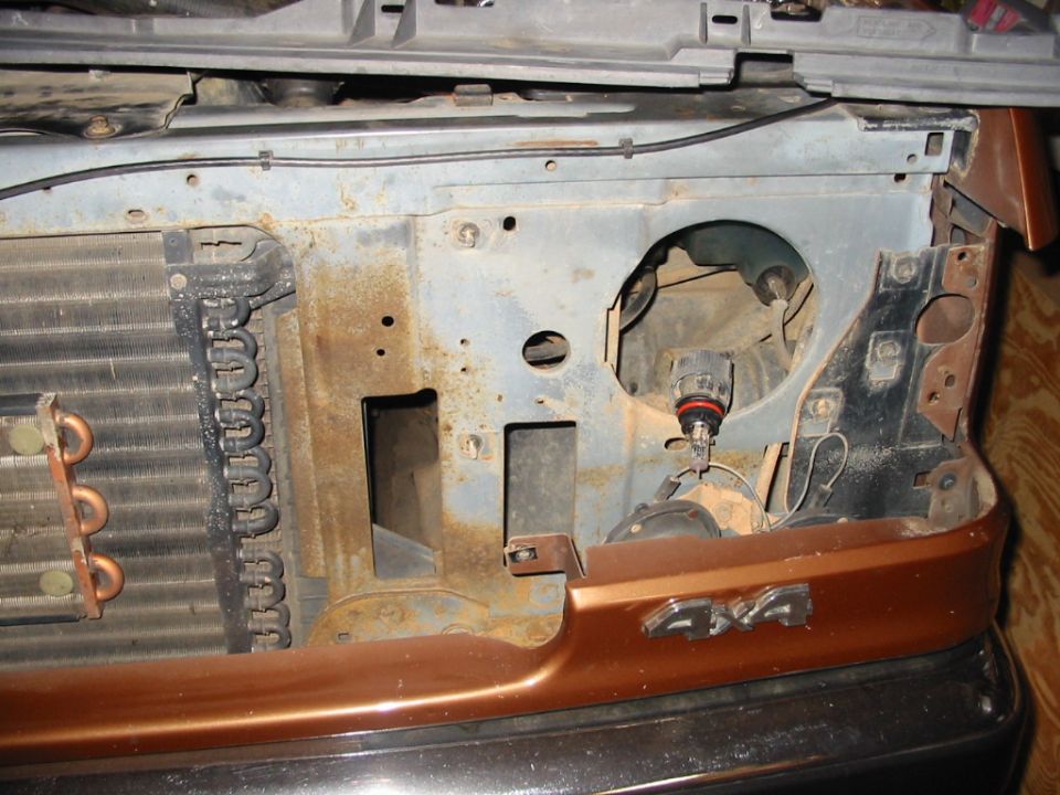 Ford truck front end with grille removed showing radiator support and headlight socket