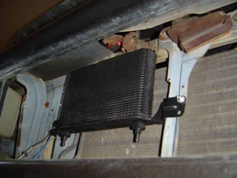 1986 Ford Bronco - A transmission cooler is installed in front of the radiator, showing its fins and mounting hardware.